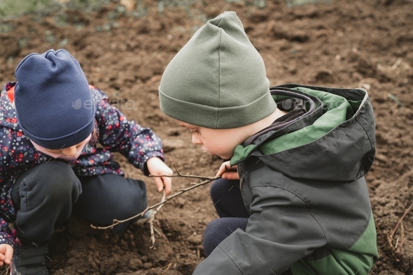 Children explore the earth in early spring.