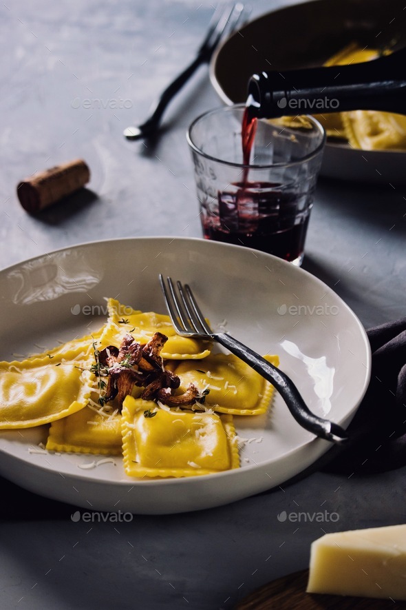Cheese ravioli pasta with chanterelle mushrooms and red wine Stock