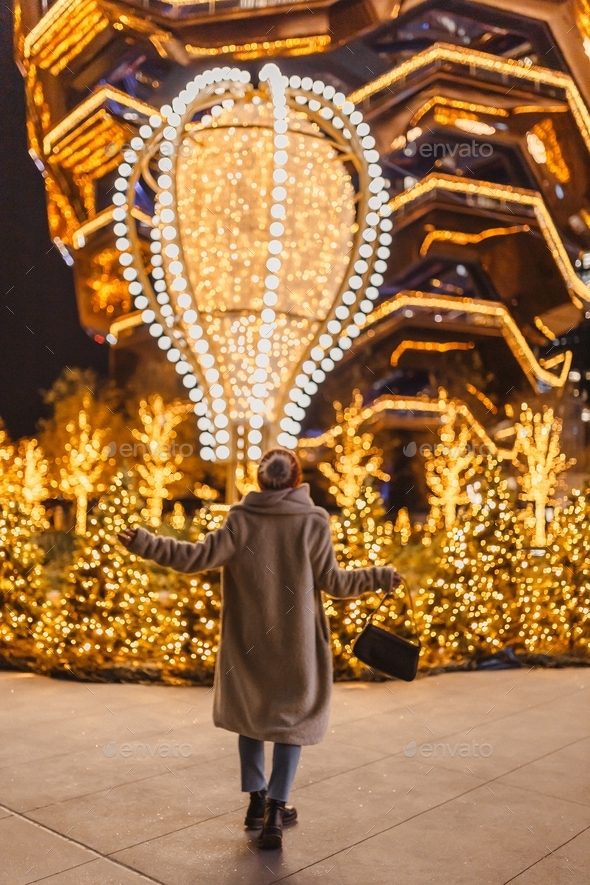 Enchanting Christmas moment. Hudson Yards Christmas lights. Young woman is looking on the lights.