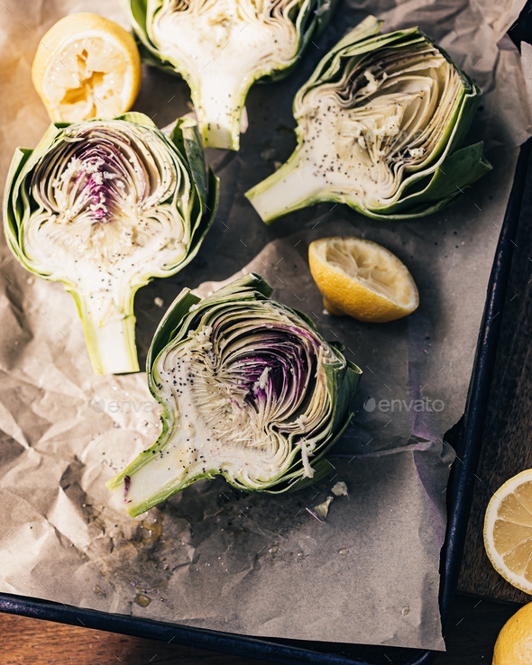 Artichokes halves on the sheet pan. Lemon juice, ready for oven