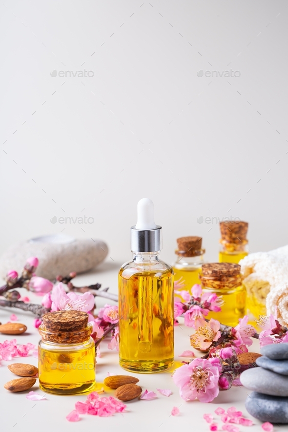 Almond essential oil in a bottles with spring blossom branches