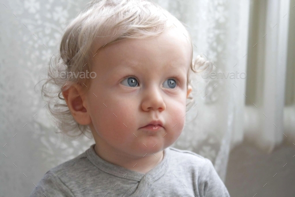 portrait of a little kid with round cheeks and big blue eyes
