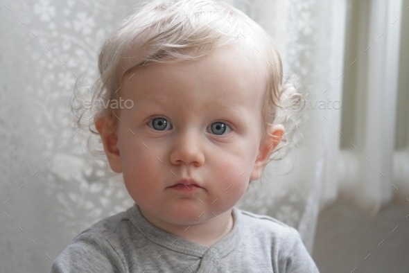 portrait of a little kid with round cheeks and big blue eyes