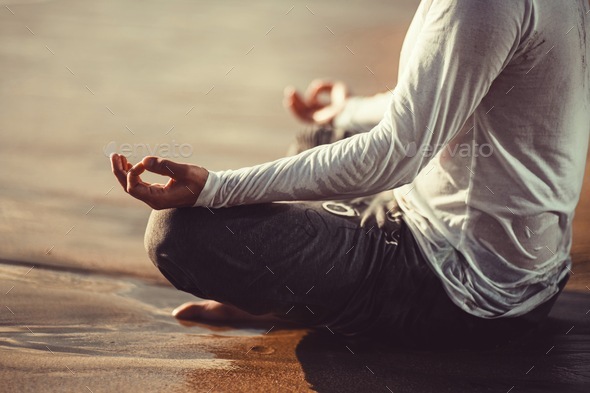 Candid authentic male millennial sitting in lotus pose gyan mudra on ...