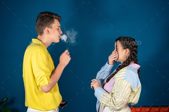 Passive smoking concept. Teen girl pinch her nose because toxic fumes
