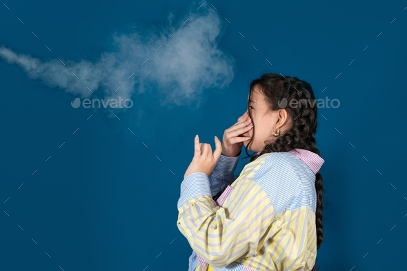 Passive smoking concept.Teen girl pinch her nose because toxic fumes from car,bad smell.