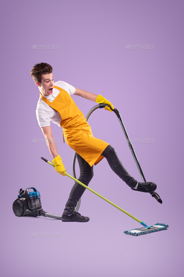 Funny man with mop and vacuum cleaner