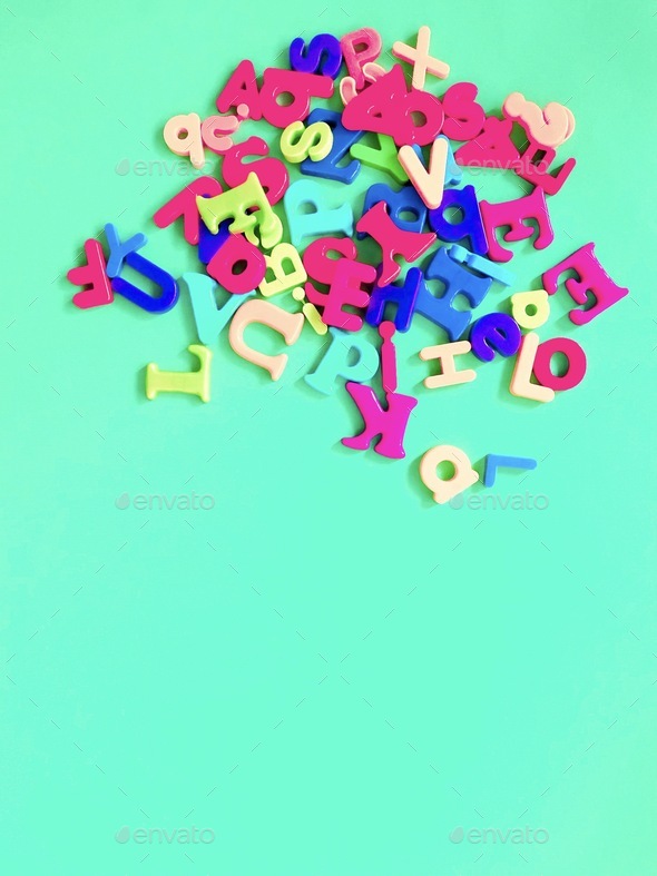 Colorful alphabet fridge magnets on colourful background with space for copy