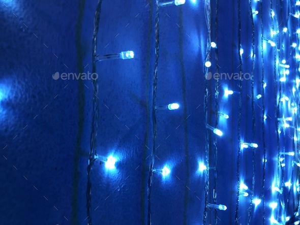 Blue fairy lights hanging on dark blue wall