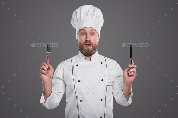 Amazed chef with knife and fork