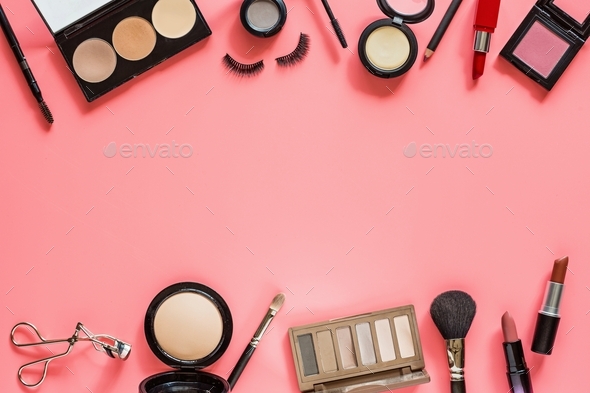 Cosmetic products on pink background with copy space. Makeup flat lay: brush, lipstick, eyelashes