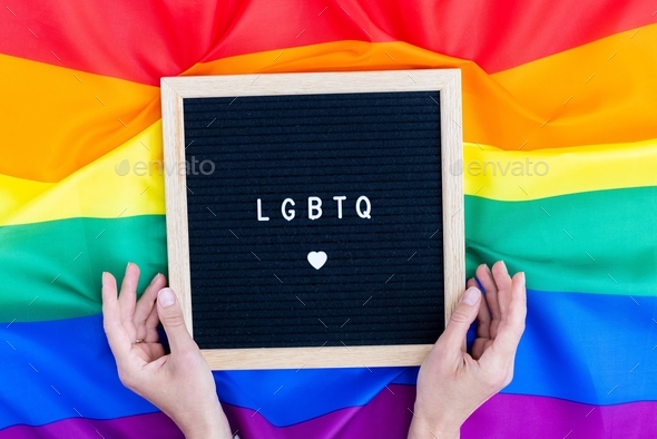 Hand holding rainbow heart on lgbt flag colours, pride month