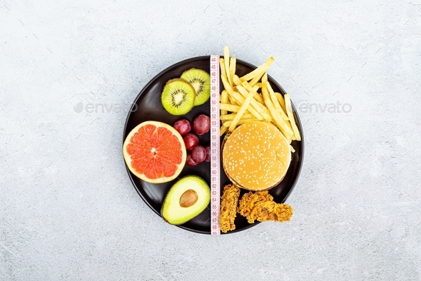 Flat lay of Healthy and unhealthy food from fruits and vegetables vs fast food, sweets and pastry