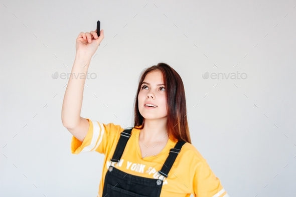 Young smiling girl student worker with dark long hair in yellow t-shirt with graphic pen in hand
