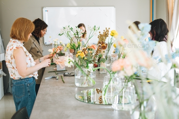 Young women make bouquets of flowers at a flower workshop