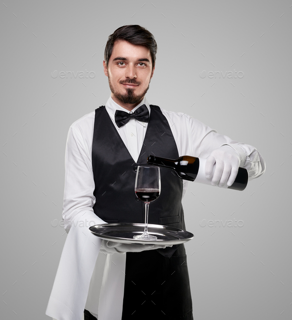 Elegant waiter serving wine in restaurant Stock Photo by kegfire
