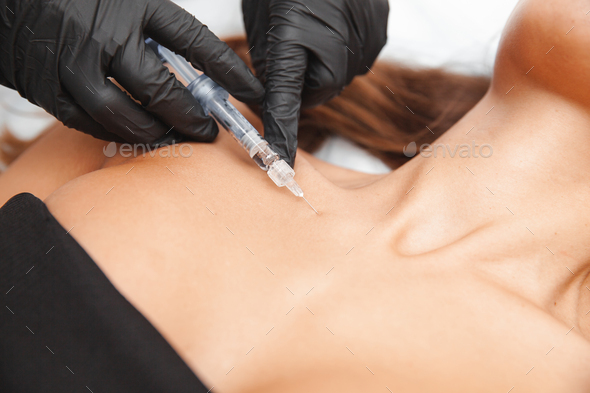 The cosmetologist makes anti-aging injections against wrinkles on the neck and in the decollete area