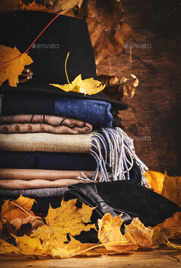 Autumn background with warm autumn and winter clothes, scarves, sweaters, felt hat, gloves