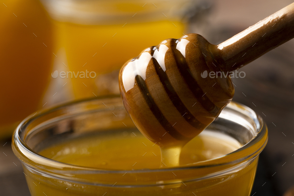 Honey on wooden honey-dipper closeup food background - Stock Photo - Images