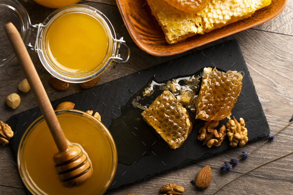 Honeycomb on slate tray with honey and nuts on kitchen table - Stock Photo - Images