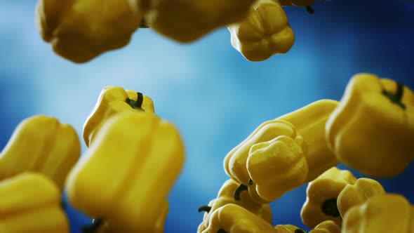 Slow motion animation of natural yellow bell peppers falling down. Loopable. HD alt