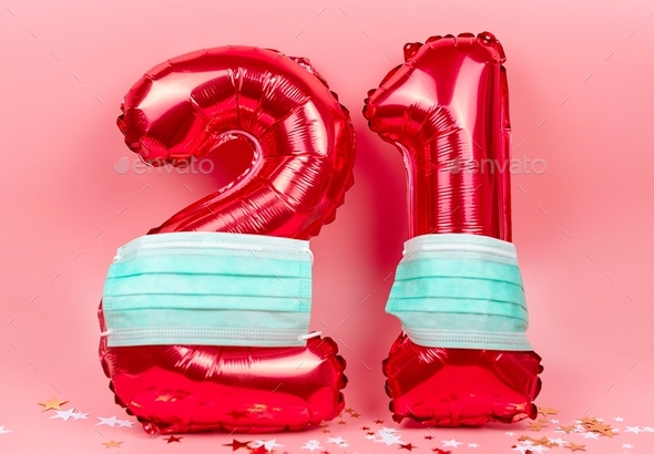 red figures 21 from balloons in protective face mask on pink background, the concept of new year