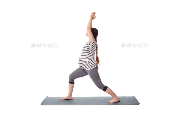 Pregnant woman doing yoga asana Virabhadrasana 1 - Stock Photo - Images