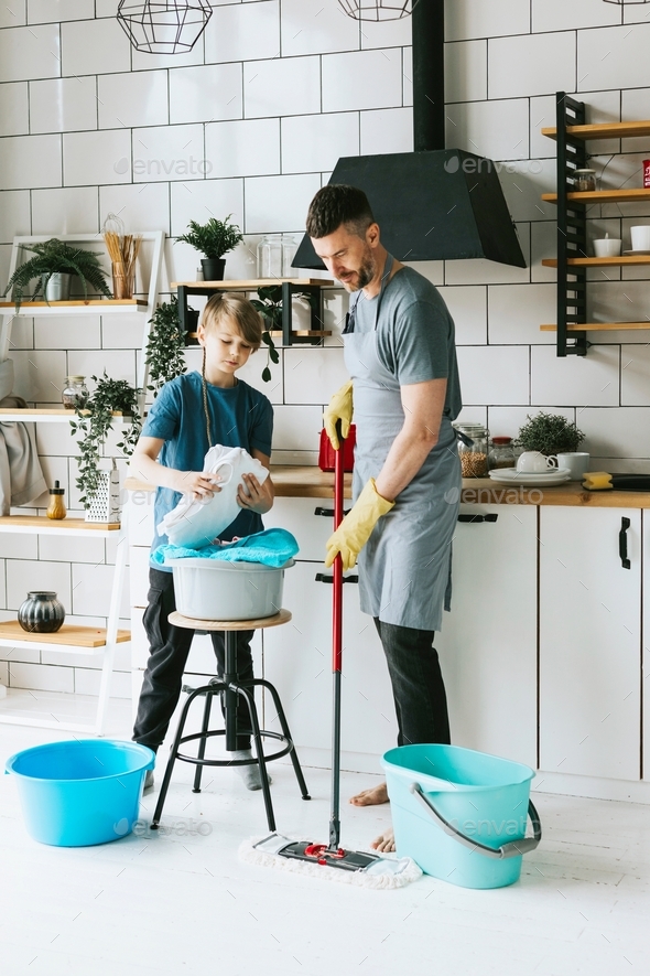family dad young man and son teenage boy in apron do household chores, men housework, household help