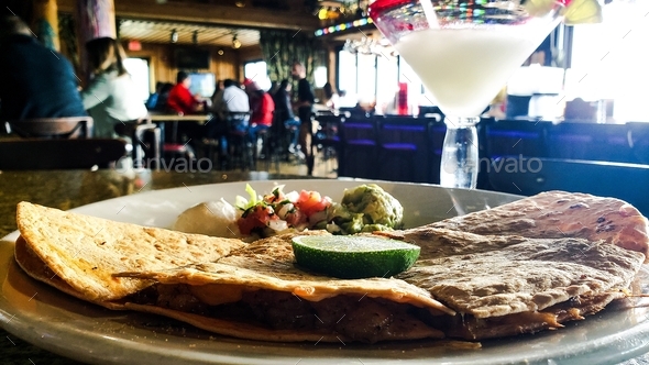 Delicious ethnic and cultural food served in Mexican restaurant with frozen margarita at happy hour.