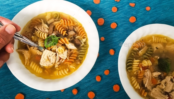 Overhead food flat lay of hot homemade chicken noodle soup used to fight illness in winter.
