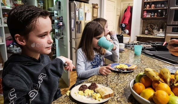 Little guy trying to eat breakfast quickly to catch school bus but must listen to grandmas lecture