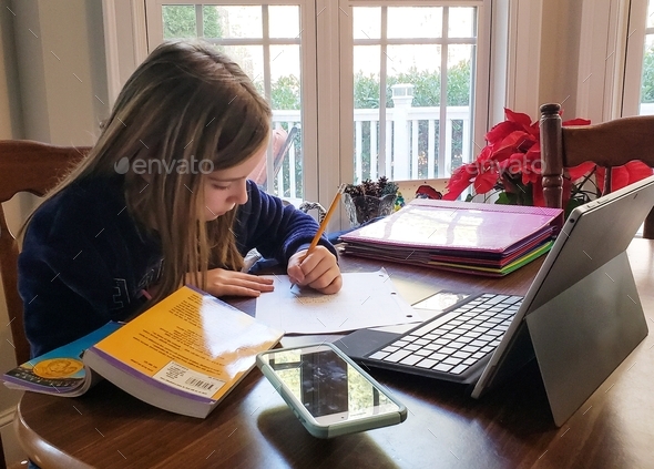 Generation z girl at home doing school Homework using technology and a ...