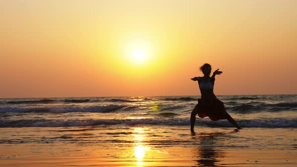 Silhouette of Young Girl Dancing at Sunset in Slow Motion