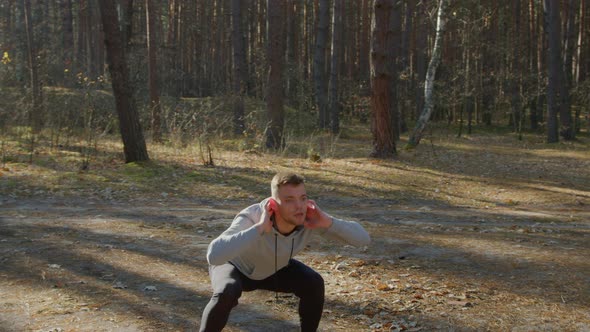 Young Man Is Warming Up In Forest Before Morning Training