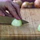 Chef Cutting the Onions on a Wooden Board