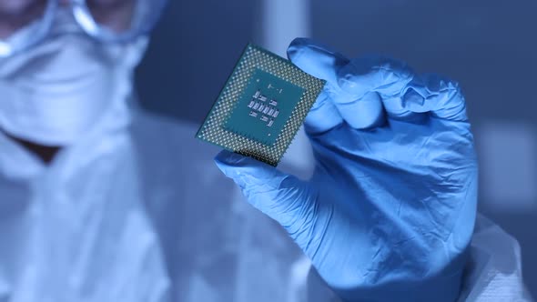 Man in clean room holds up computer cpu microchip alt