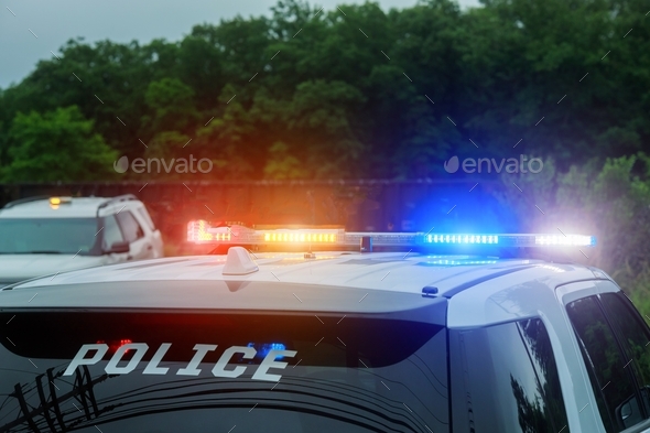 Red and blue flashing lights on police car on patrol Stock Photo by photovs