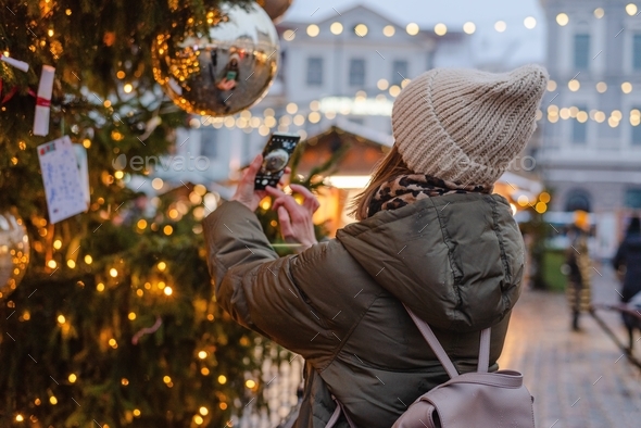Woman taking photo at Christmas market  - Stock Photo - Images