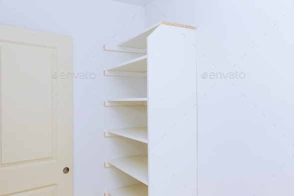 installation of shelves with a shelf near of big cabinet. Furniture installation.