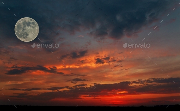 red sky during sunset with a big moon in the full moon phase and the silhouette of a small plane