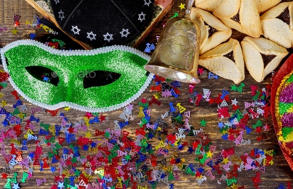 Purim jewish holiday with purim mask and purim a noisemaker on a vintage wood background with kosher