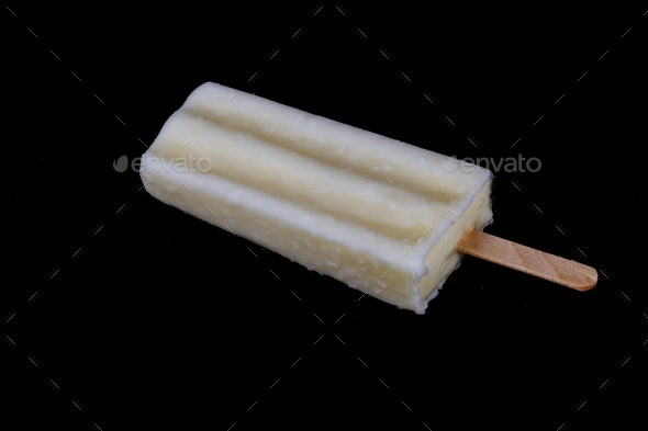 Frozen white fruity yogurt on a stick with missing bite, isolated on black