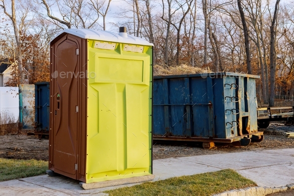 Portable chemical toilets for construction new house and recycling container trash dumpster full