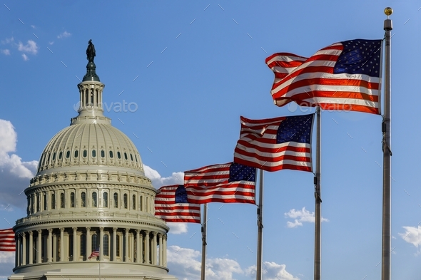 Capitol building in Washington, DC with United States flags on the sky