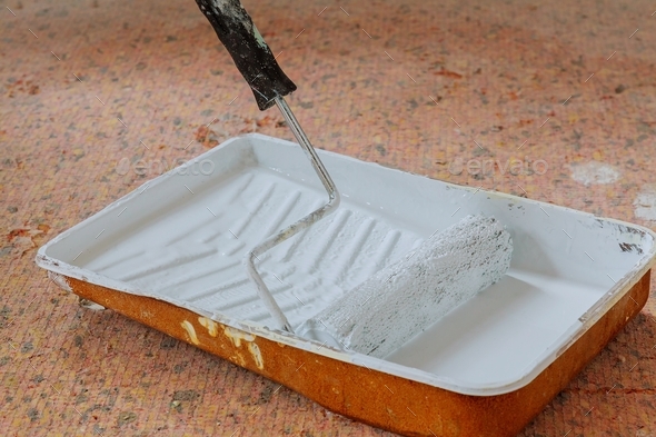 Realistic image of paint pan and roller on drop cloth during painting project