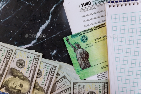 Refund check US., 1040 individual tax return form Tax return and dollar cash and blank notebook
