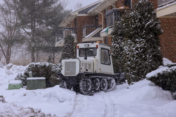 Tractor snow clearing road maintenance with heavy snowfall