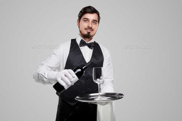 Elegant waiter serving wine in restaurant