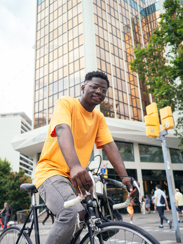 Smiling african american young man with a bicycle in the city. Sustainable mobility