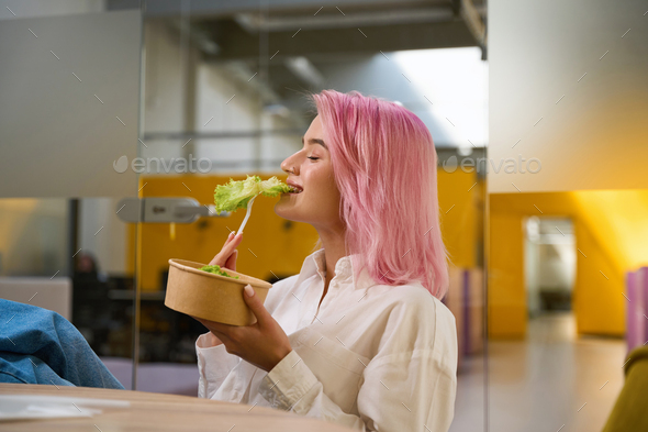 Young lady having lunch in the office - Stock Photo - Images